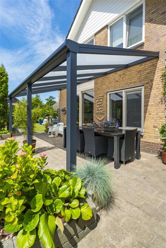 Aluminium veranda with glass roof over a garden dining area