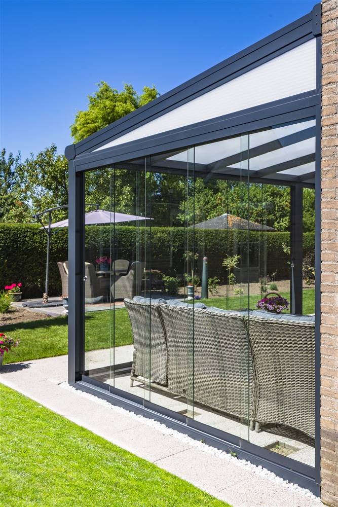 Glass room veranda with rattan garden furniture inside